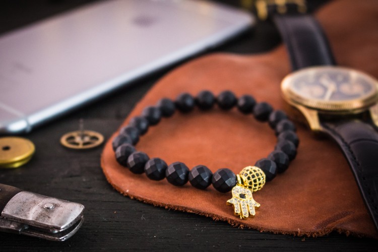 Ignas - 8mm - Matte Black Faceted Onyx Beaded Stretchy Bracelet with Gold Micro Pave Hamsa Hand Charm & Ball from STRAPSANDBRACELETS