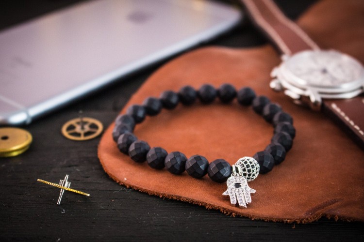 Kaelenn - 8mm - Matte Black Faceted Onyx Beaded Stretchy Bracelet with Silver Micro Pave Hamsa Hand Charm & Ball from STRAPSANDBRACELETS